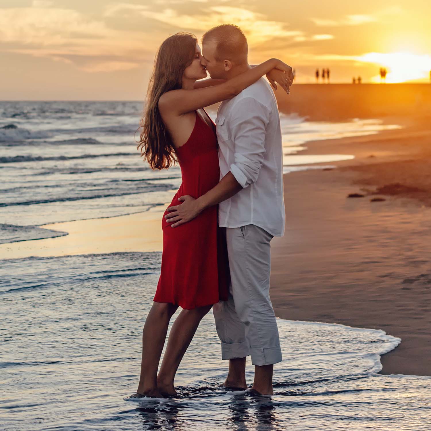 Happy couple kissing in sunset. In beach loving each other.